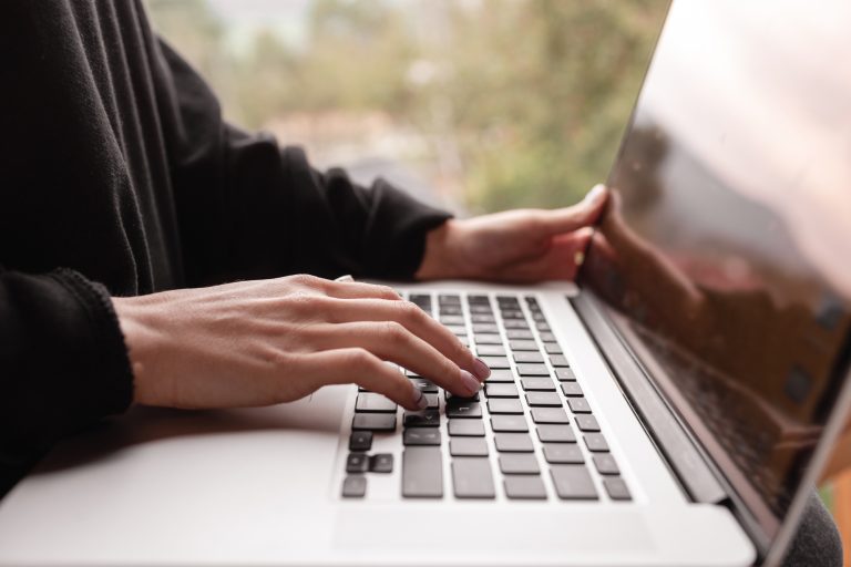Email marketing B2B and newsletter concept. Hand of man sending message and laptop.