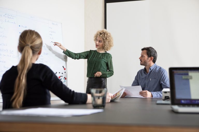 Woman in boardroom leading a presentation about lead qualification b2b